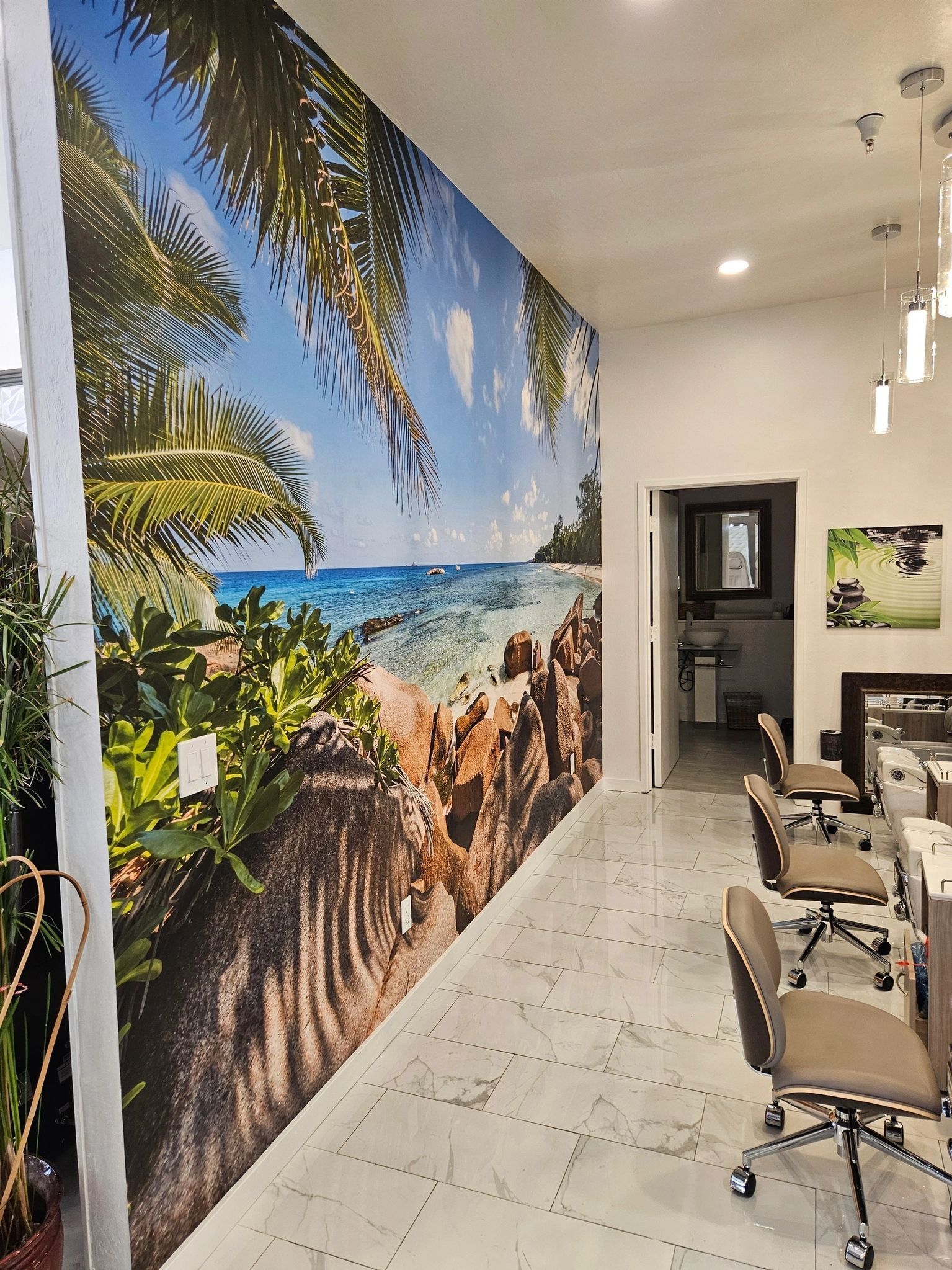 A room with a large picture of a beach on the wall.