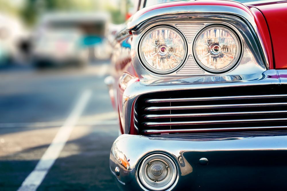 A Close Up of the Front of an Old Red Car Parked on the Side of the Road — About Town Windscreen Repairs & Replacements in Wulguru, QLD