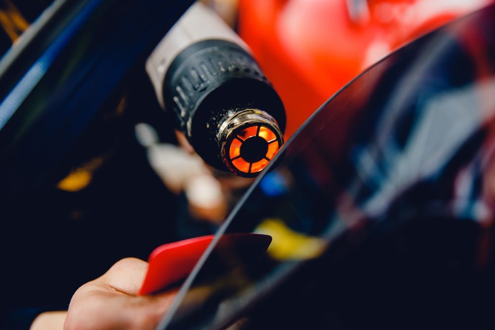 A Person Hitting the Tinted Car Window — About Town Windscreen Repairs & Replacements in Wulguru, QLD