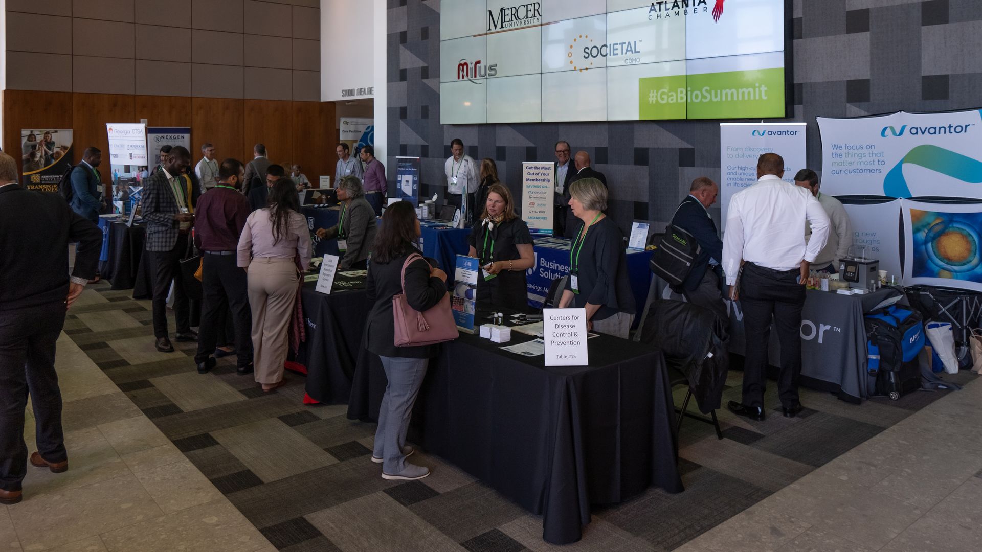 Conference attendees interacting with vendors at an expo