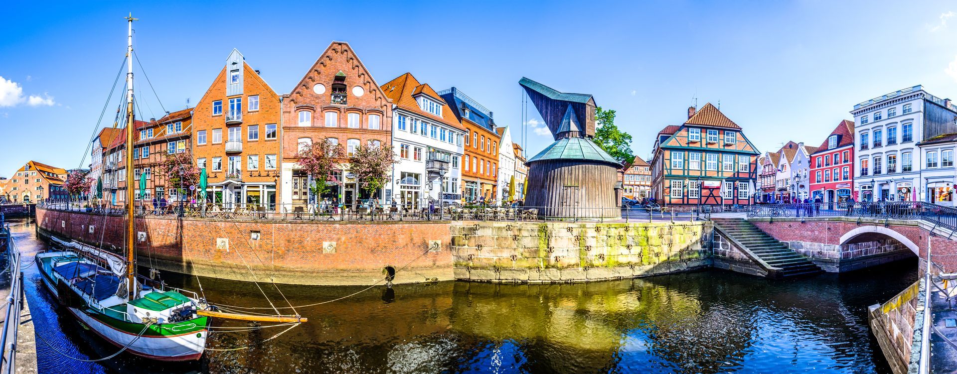 Ein Kanal, gesäumt von farbenfrohen Gebäuden und Booten unter einem teilweise bewölkten Himmel
