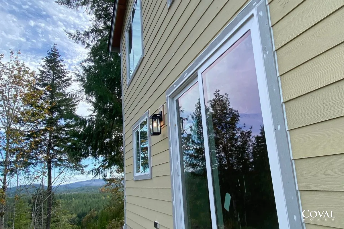 Yellow house siding with sliding glass doors overlooking a scenic mountain view