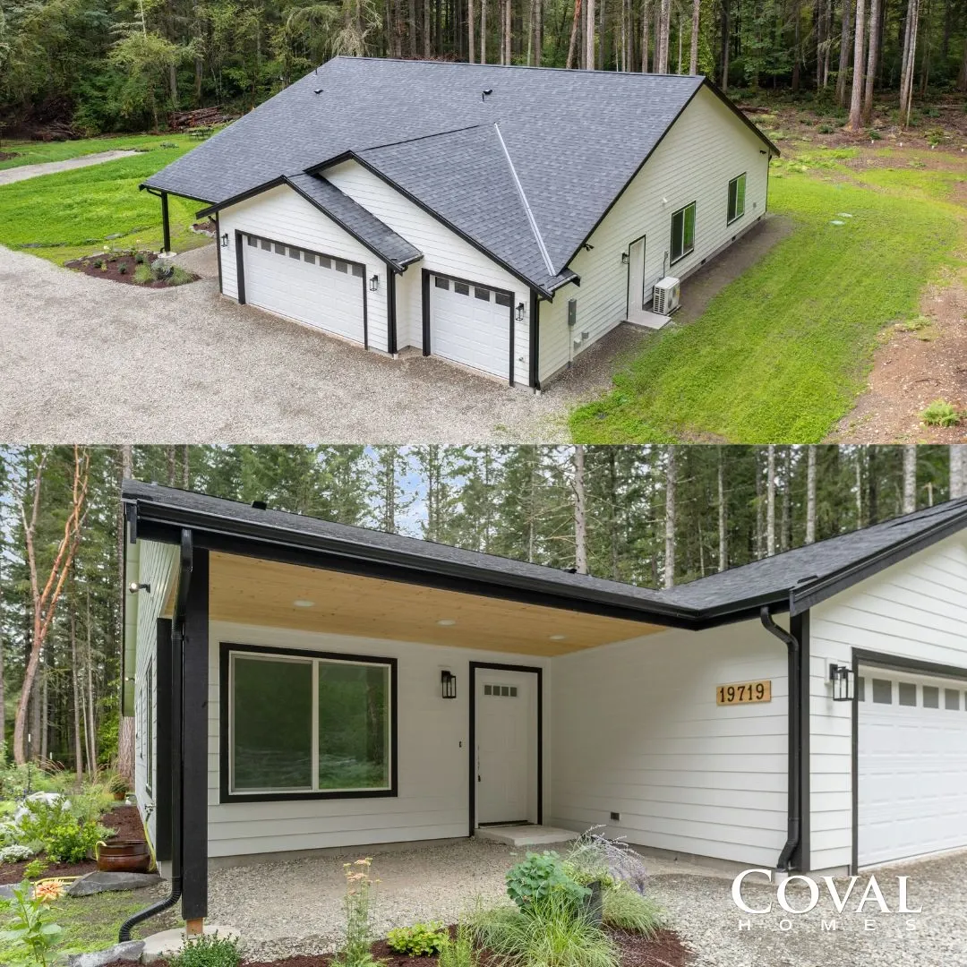 Modern white duplex house with gray roof, front porch, and two garage doors in a wooded setting