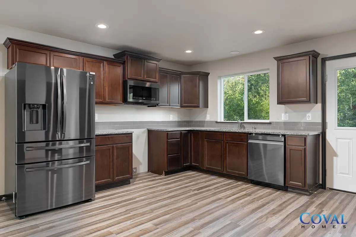Modern kitchen with stainless steel appliances, dark wood cabinets, and a striped floor runner