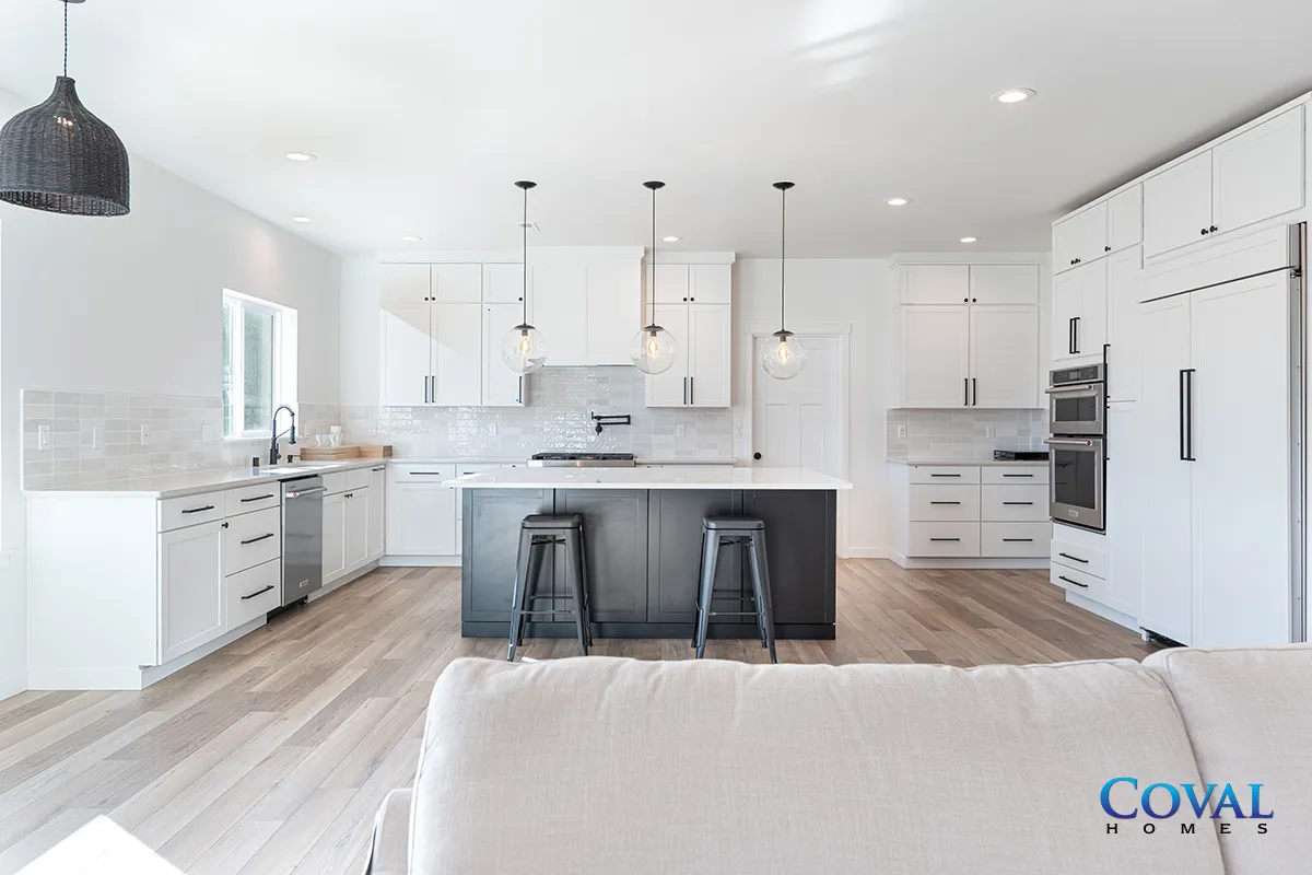 Bright modern white kitchen with island, two stools, and light wood floors