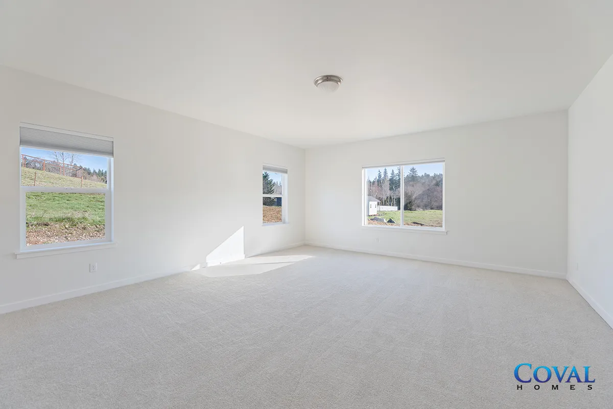 Empty white carpeted room with three windows and bright natural light