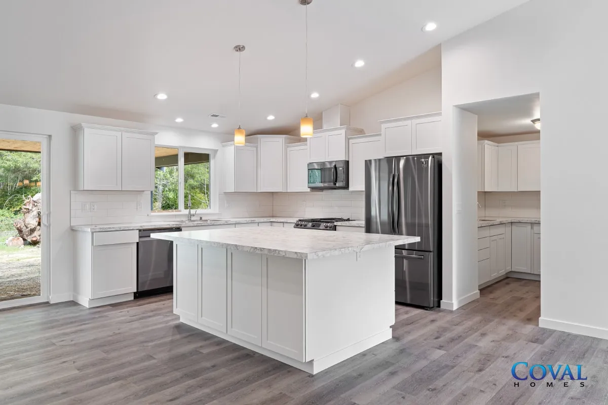 Bright modern white kitchen with island, stainless steel appliances, and gray wood flooring