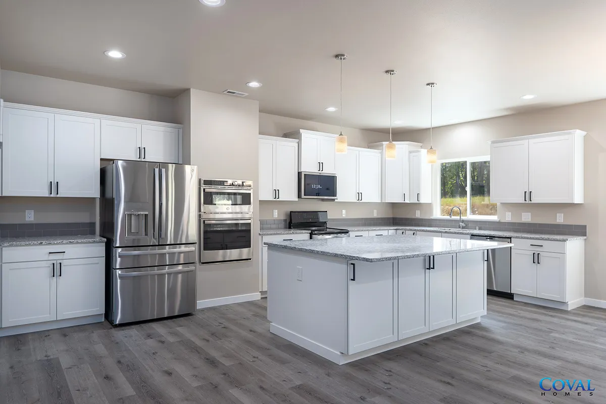 Modern white kitchen with stainless steel appliances and a large island