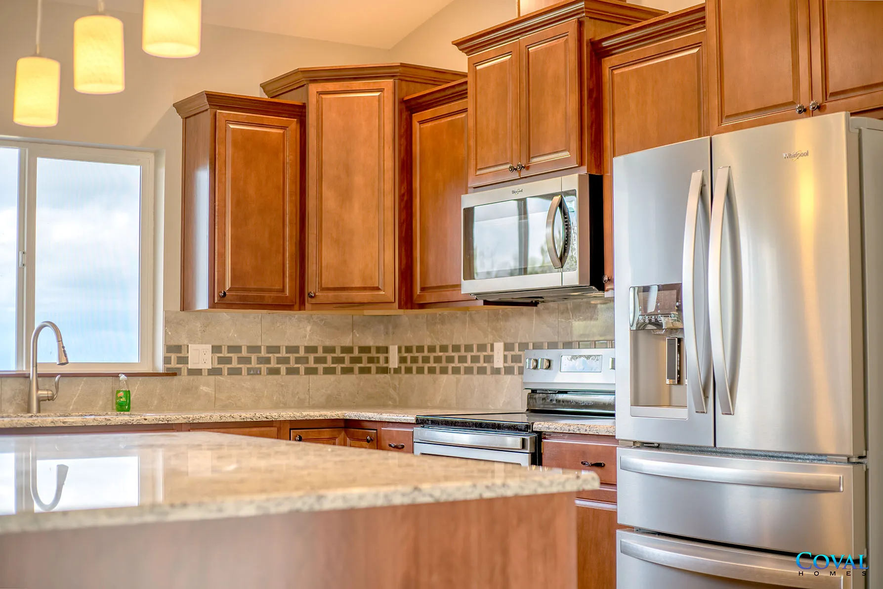Modern kitchen with wooden cabinets, stainless steel appliances, and a granite island counter
