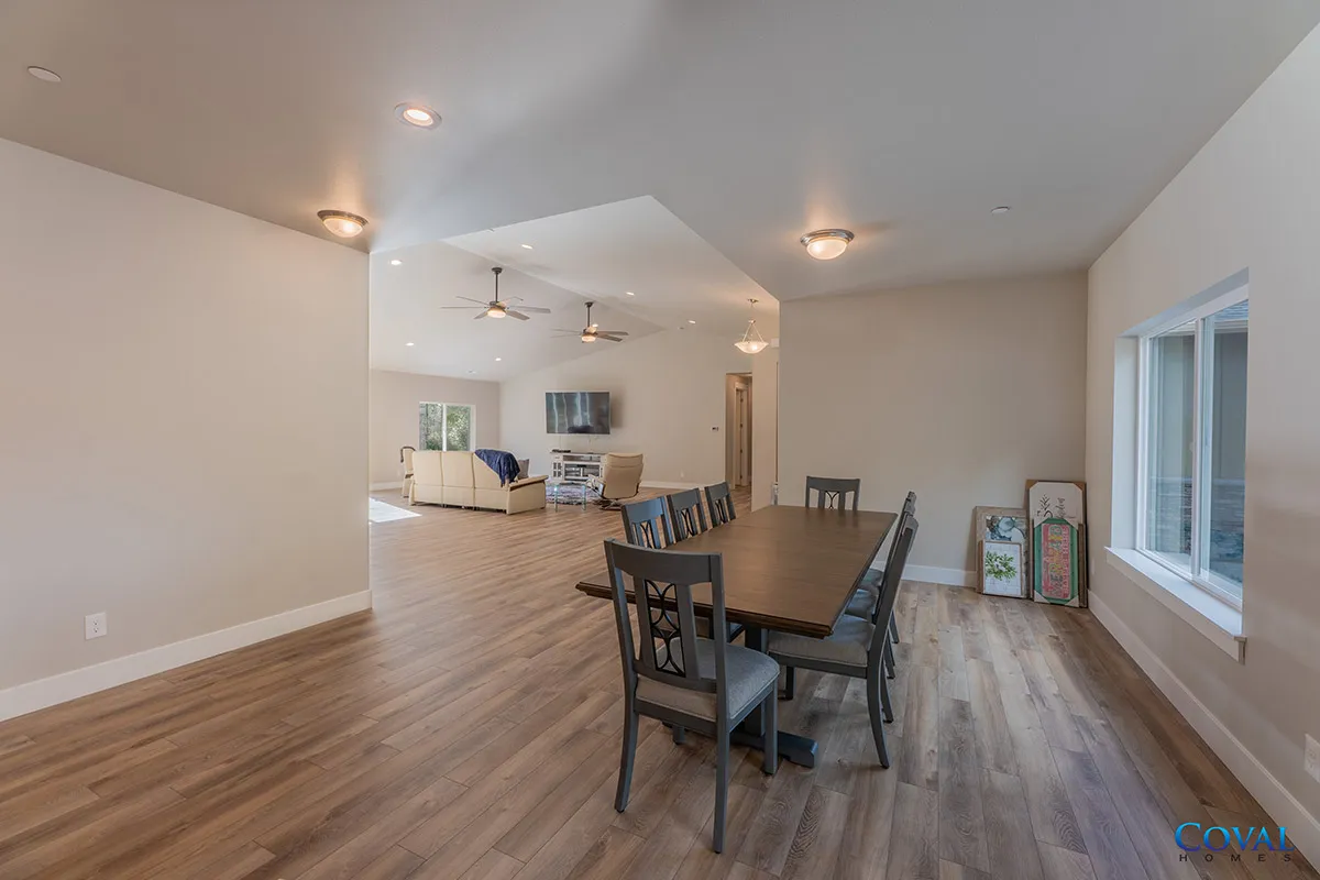 Open living and dining area with wood floors, neutral walls, and large windows.