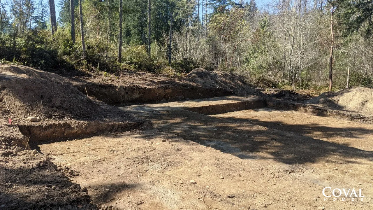 Dirt clearing with a stepped embankment beside a wooded area in daylight