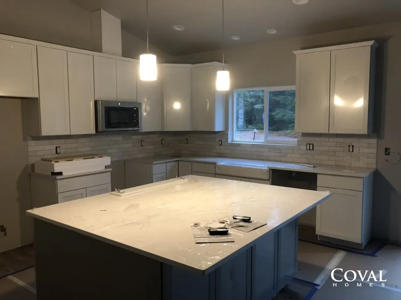 Modern kitchen with white cabinets, large island, and pendant lights