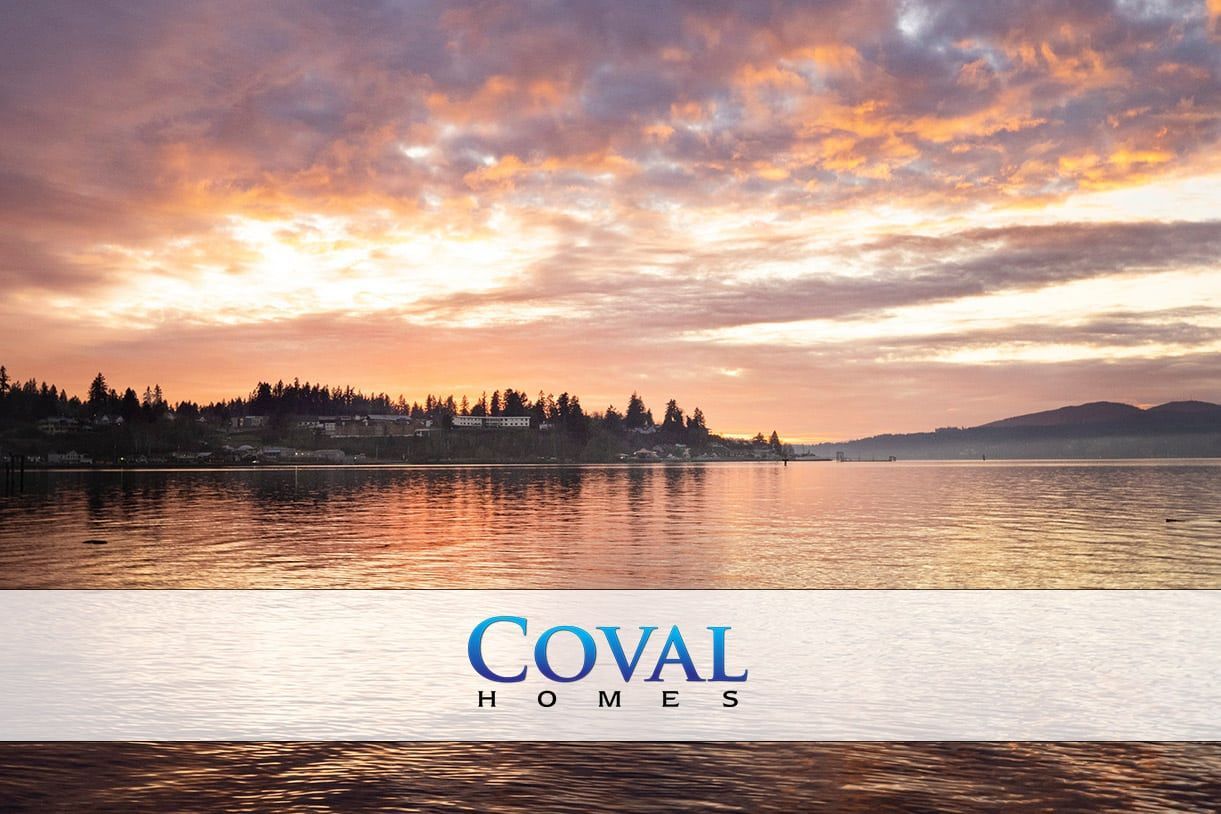 Sunset over calm water with COVAL HOMES logo centered near the bottom