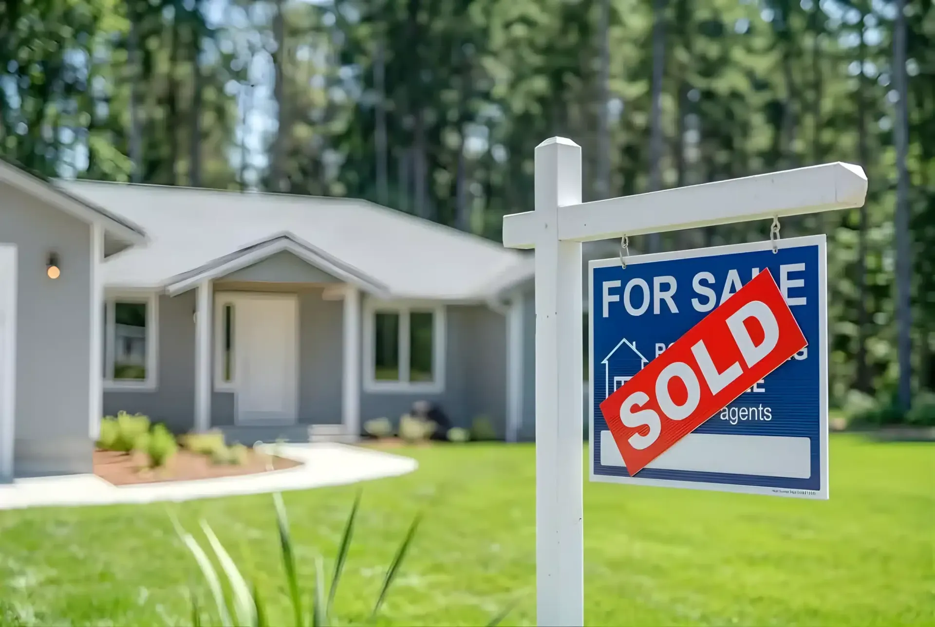 Sold sign on a for-sale house in a suburban yard