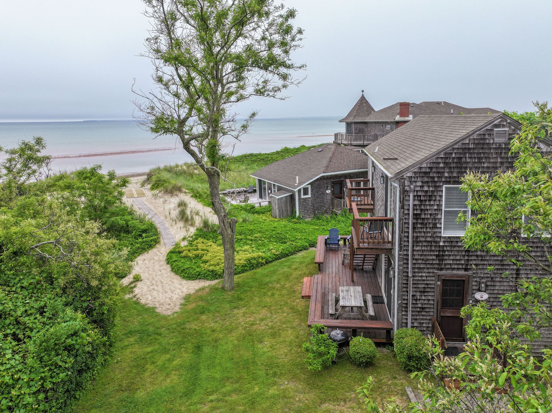 An aerial view of a house with a deck overlooking the ocean.