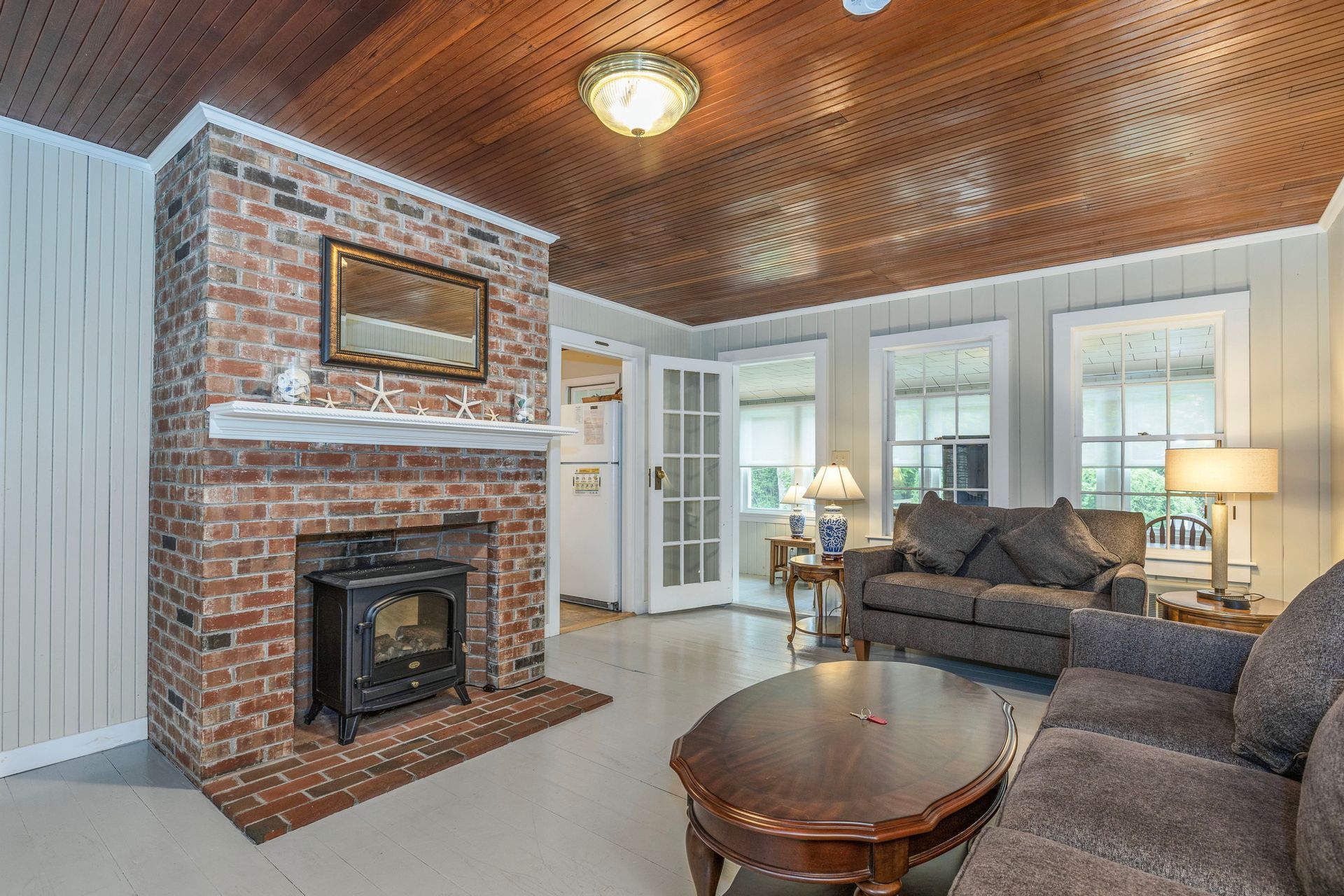 A living room with a brick fireplace and a couch.