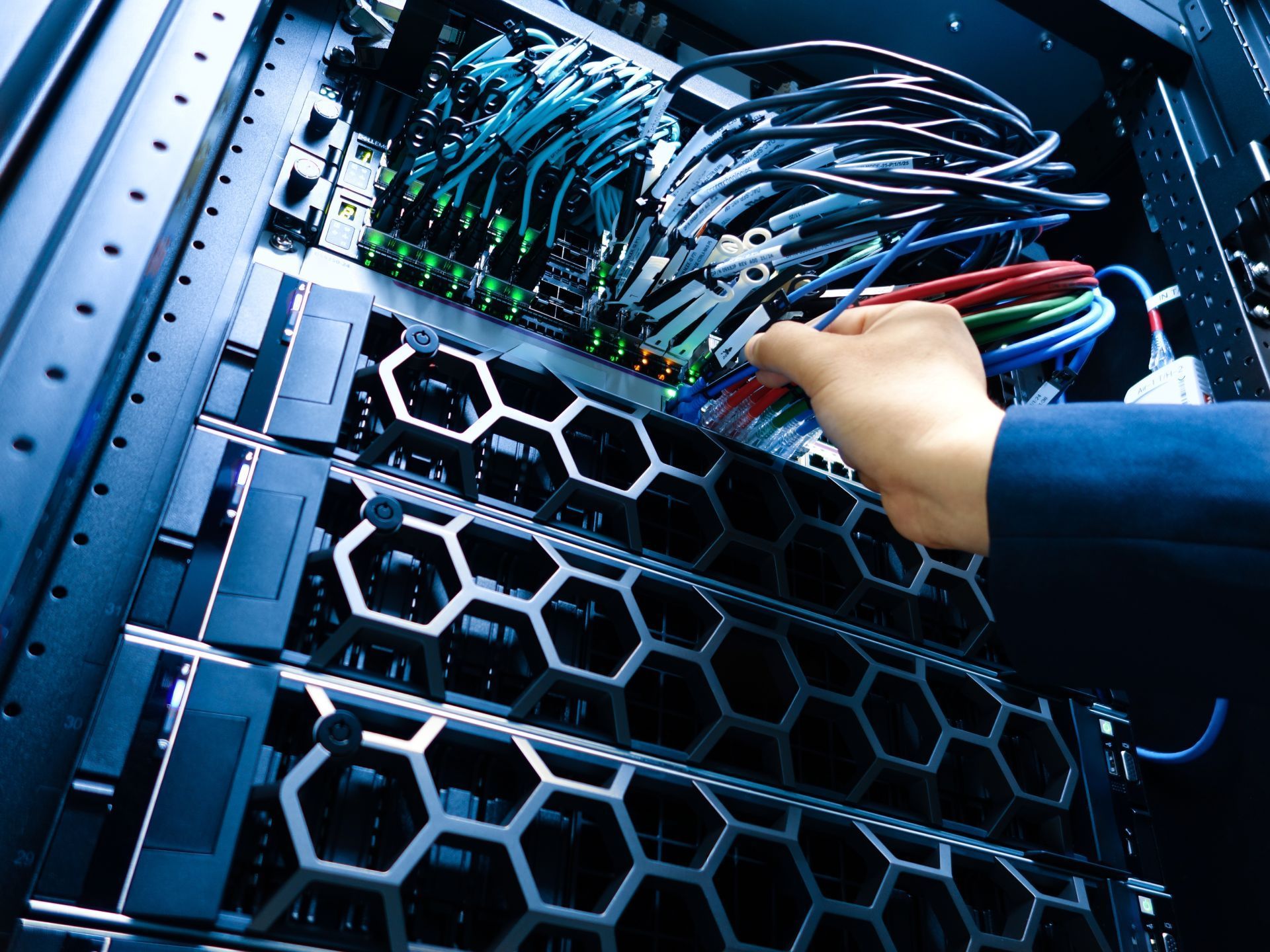 Server rack with orange fiber optic cables lit up.