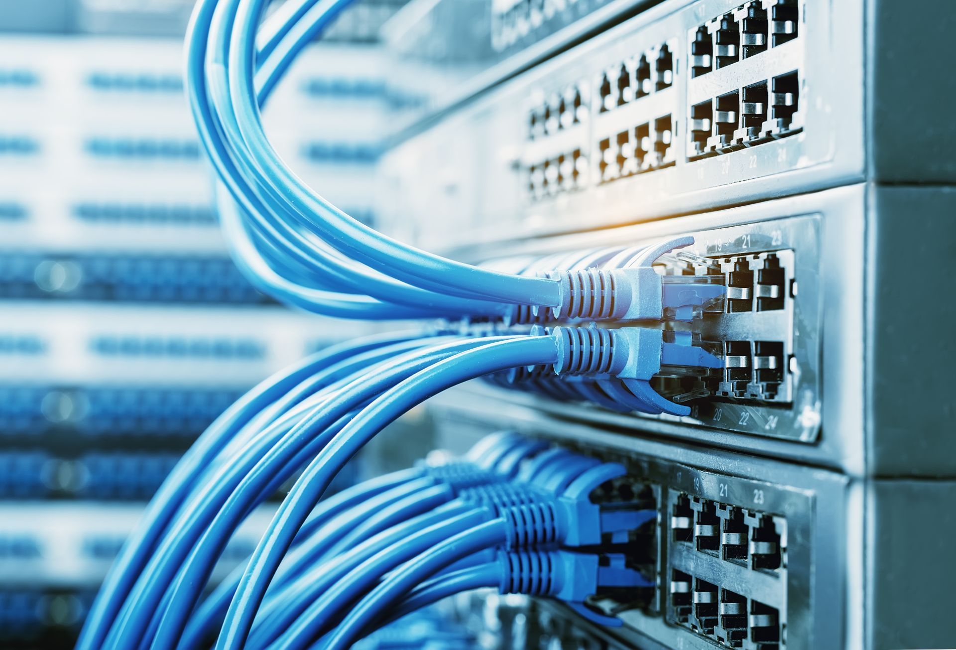 Server rack with orange fiber optic cables lit up.