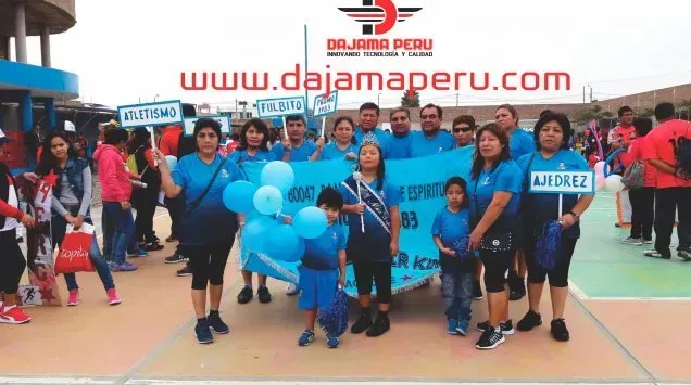 Grupo de personas con camisetas azules posando en un evento deportivo con una pancarta de “dajamareu.com” al fondo.
