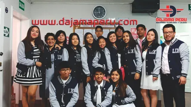 Grupo posando en interiores con uniformes idénticos en blanco y negro frente a una pared con un letrero de un sitio web.