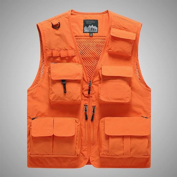 Chaleco utilitario de color naranja brillante con múltiples bolsillos sobre un fondo gris liso.