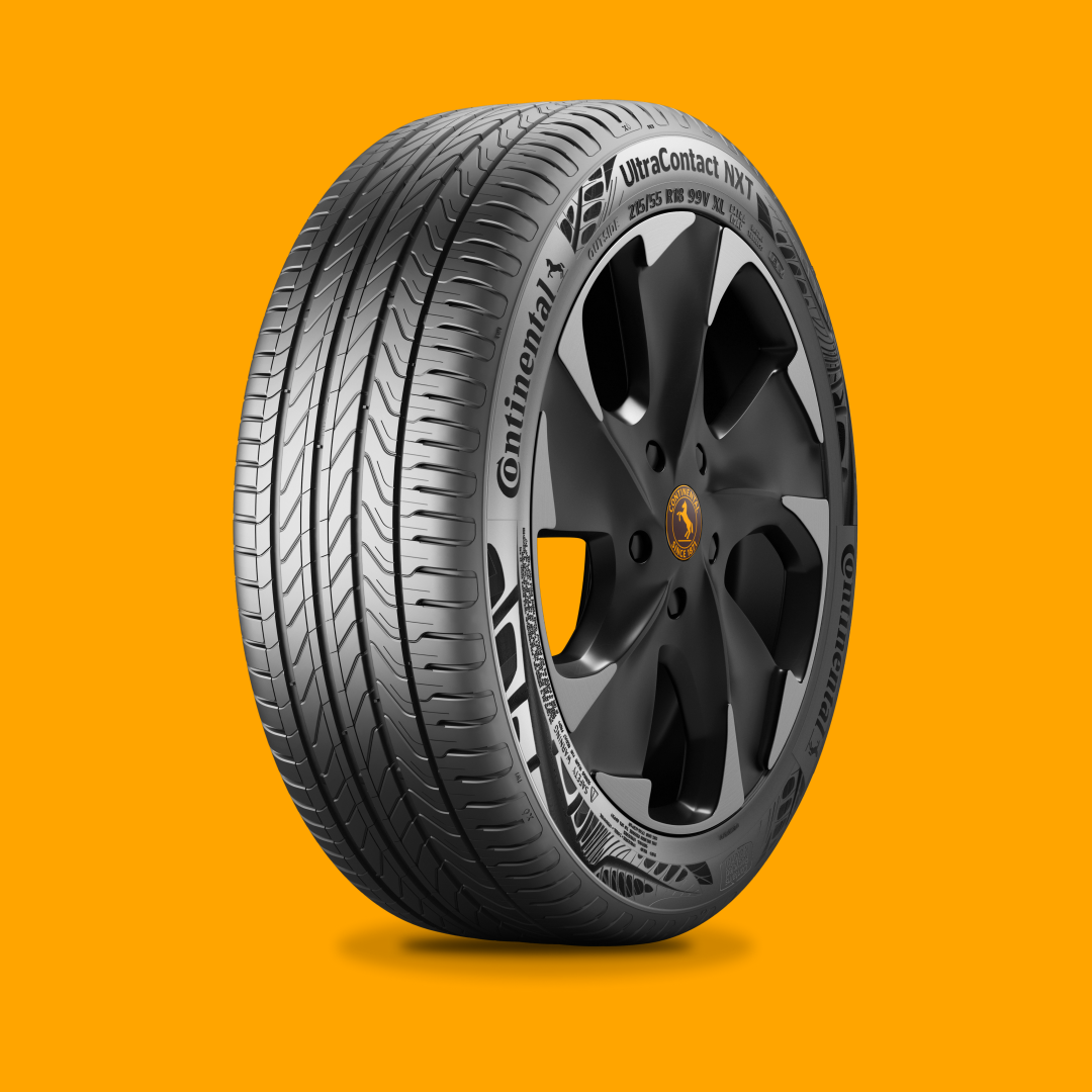 Pneu Continental montado em uma roda de liga leve preta, em contraste com um fundo laranja.