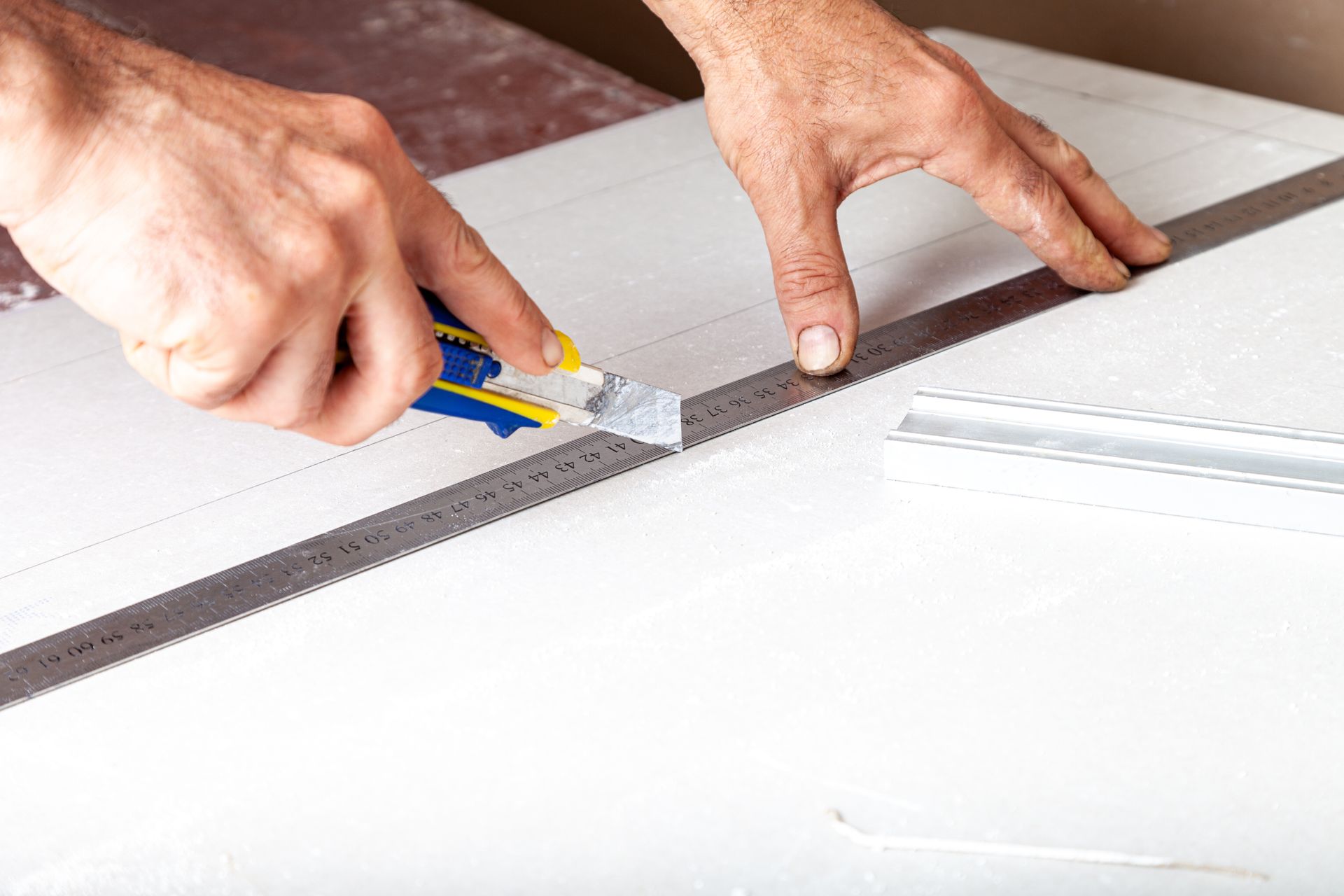 man cutting gypsum for drywall