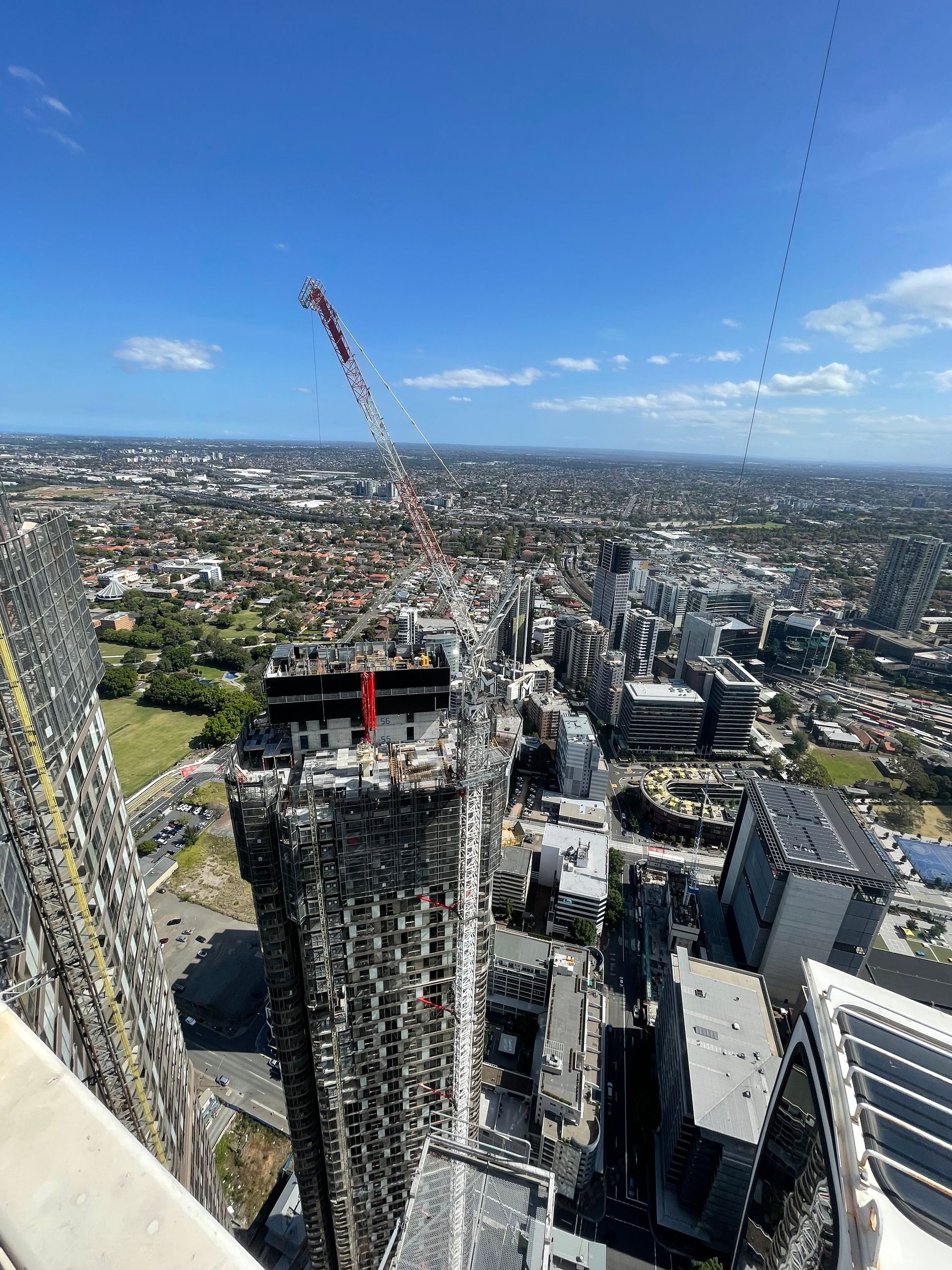 Construction crane over a high-rise building site at sunset amid city skyscrapers