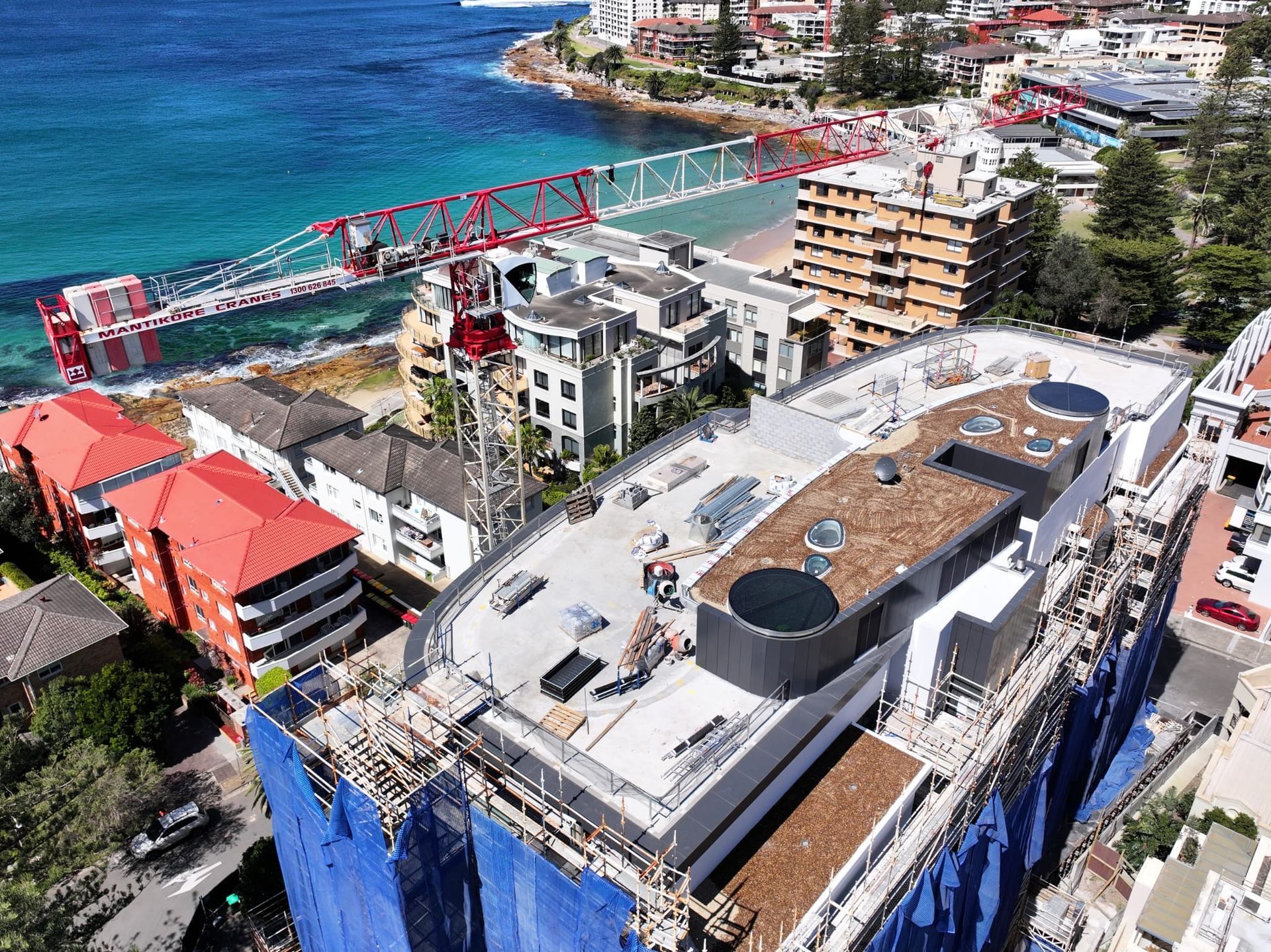 Mobile crane on active NSW building site mid-lift
