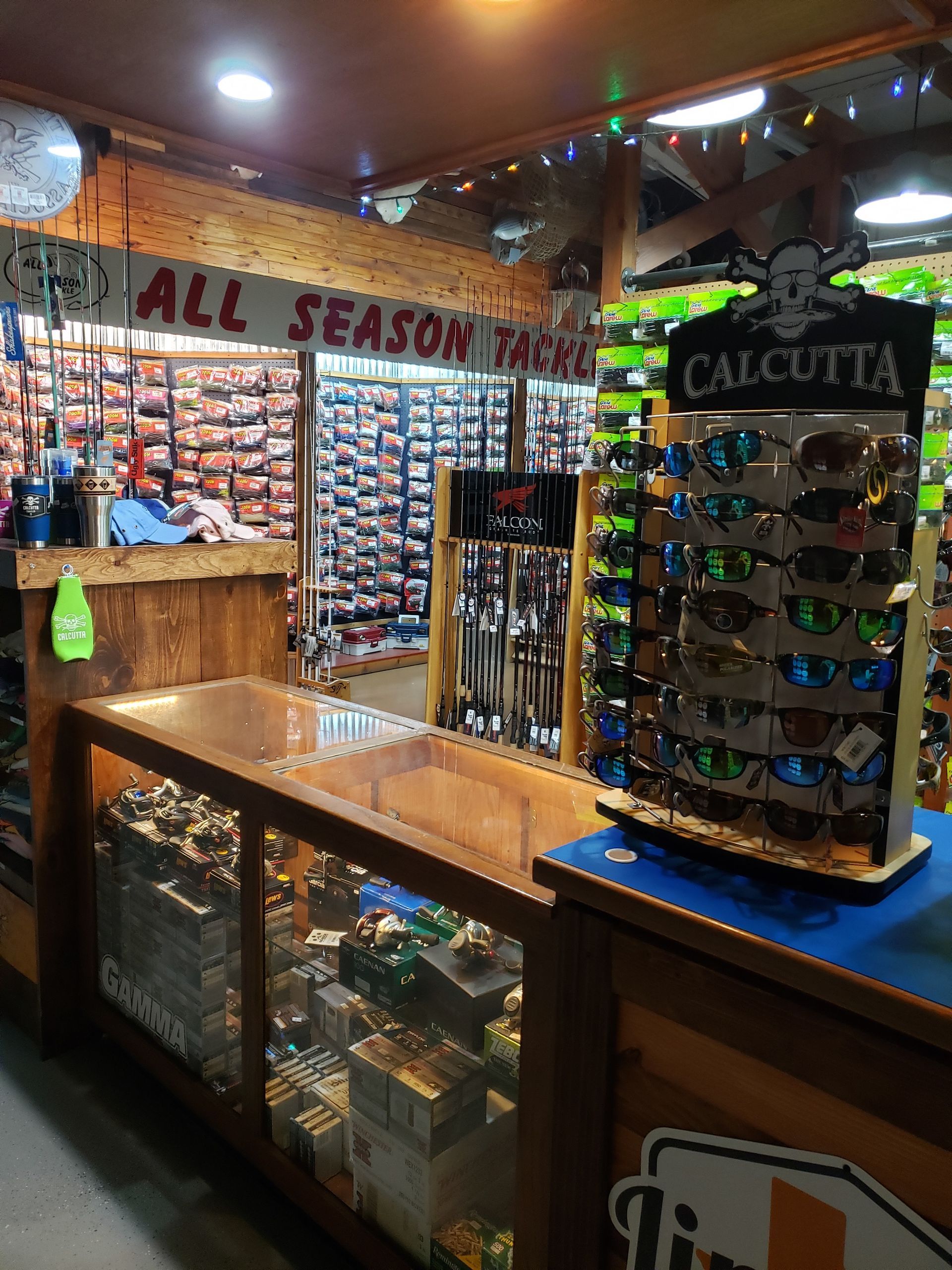 Sunglasses display in a souvenir shop with wood counters, warm lighting, and a “Calcutta” sign