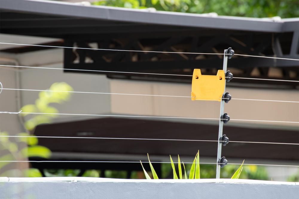 a Close Up of a Fence With a Yellow Sign on It — Tony Sinclair Fencing in Bucca, Nsw