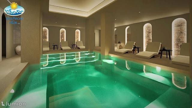 Lussuosa piscina interna con acqua turchese, nicchie ad arco, lettini prendisole e calda illuminazione d'atmosfera.