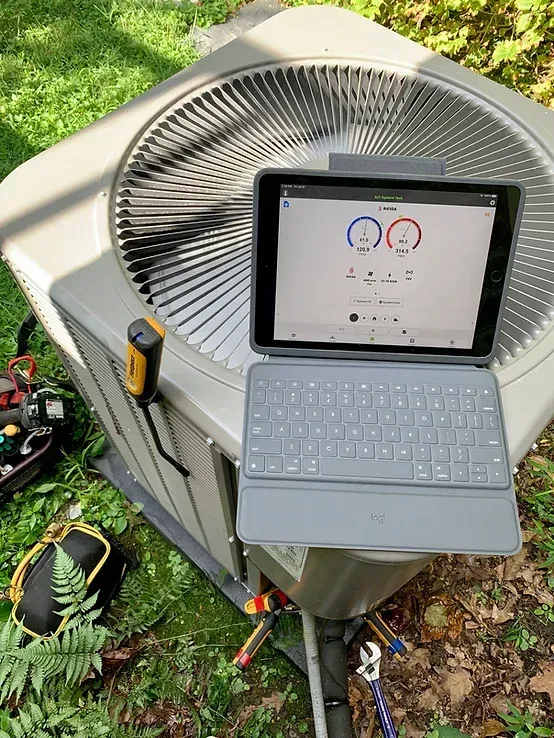 A laptop is sitting on top of an air conditioner.