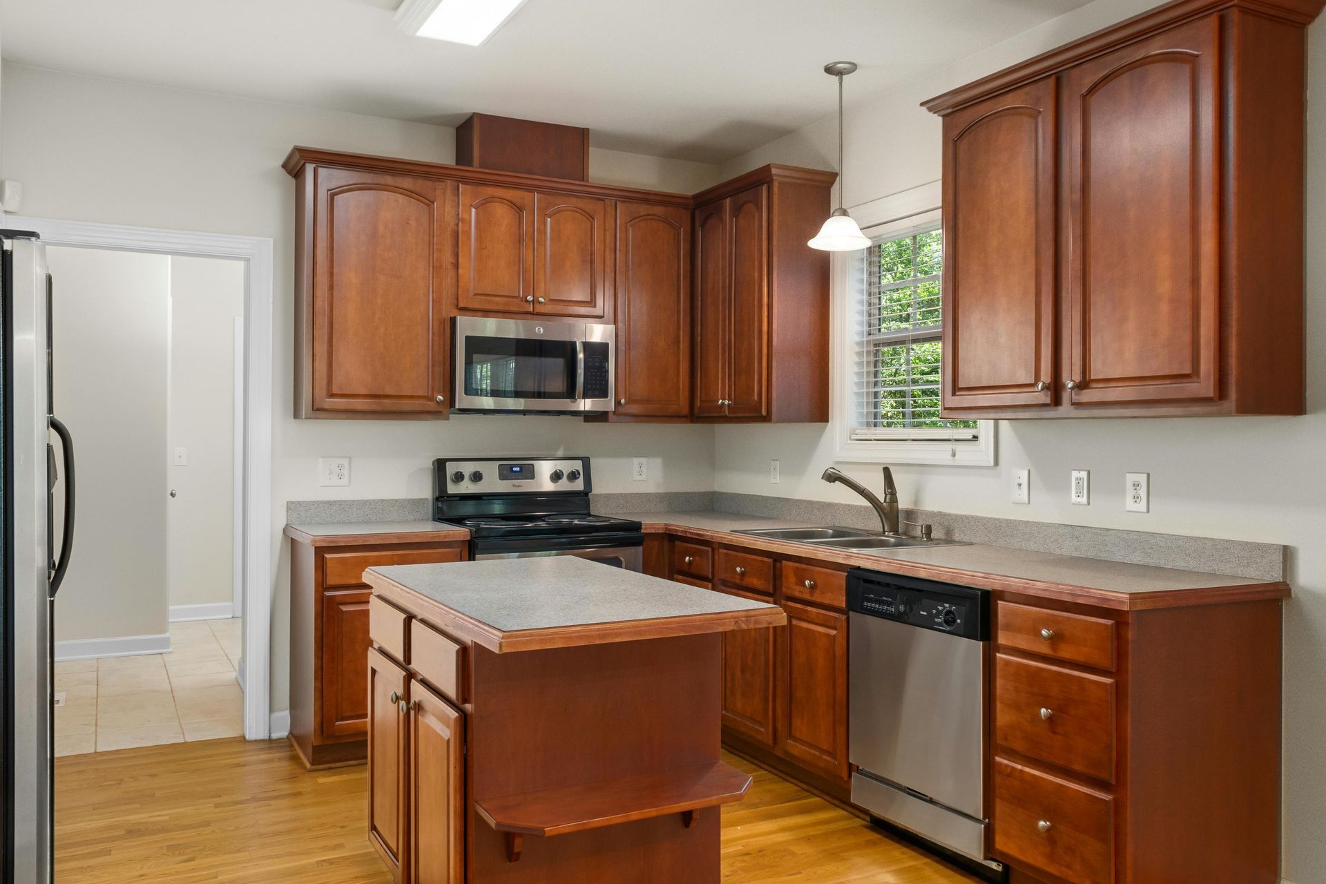 Kitchen with brown cabinets, stainless steel appliances, and island.