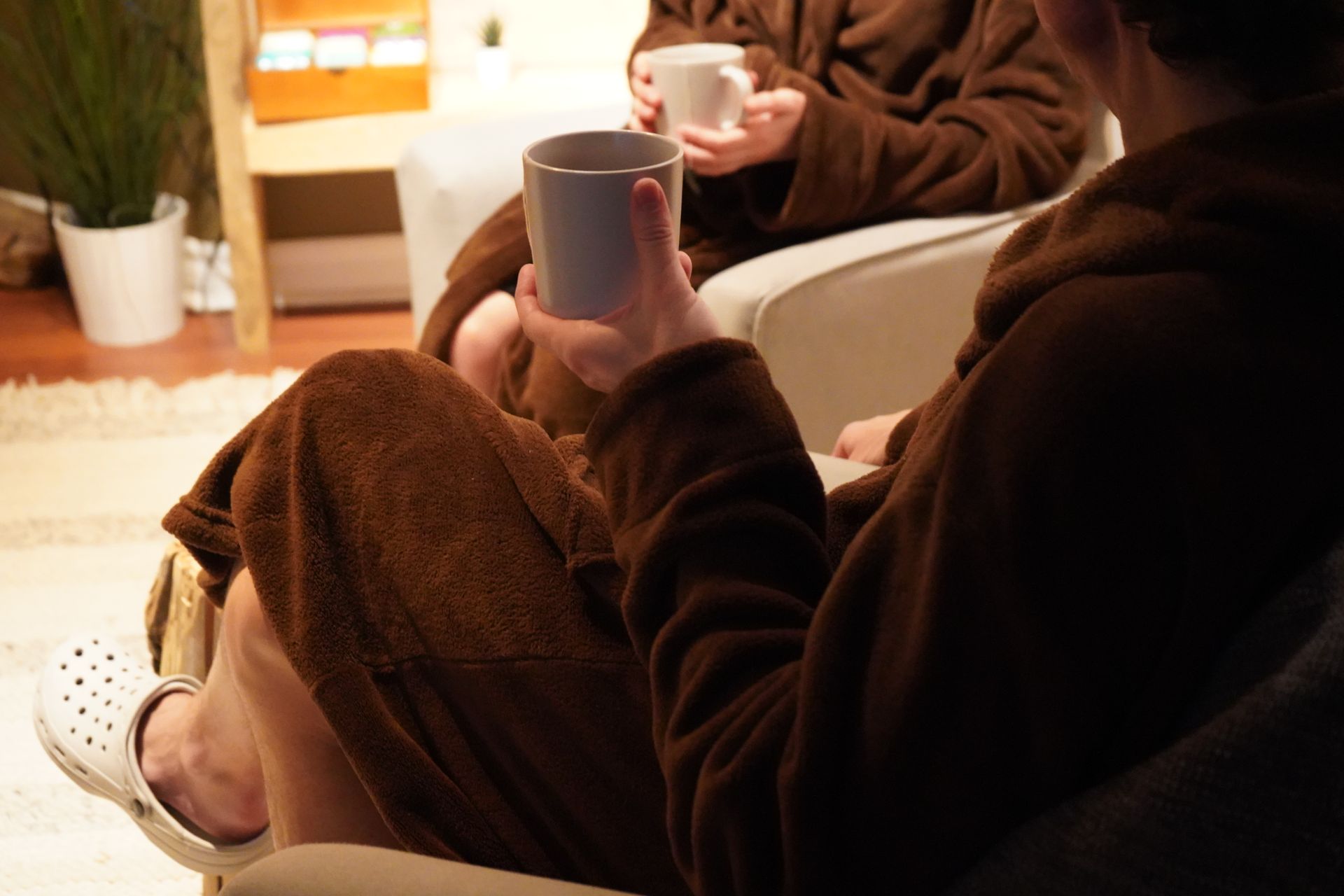 Clients en peignoir prenant le temps de relaxer avec une boisson chaude après leur expérience au Spa Centrale Parc.