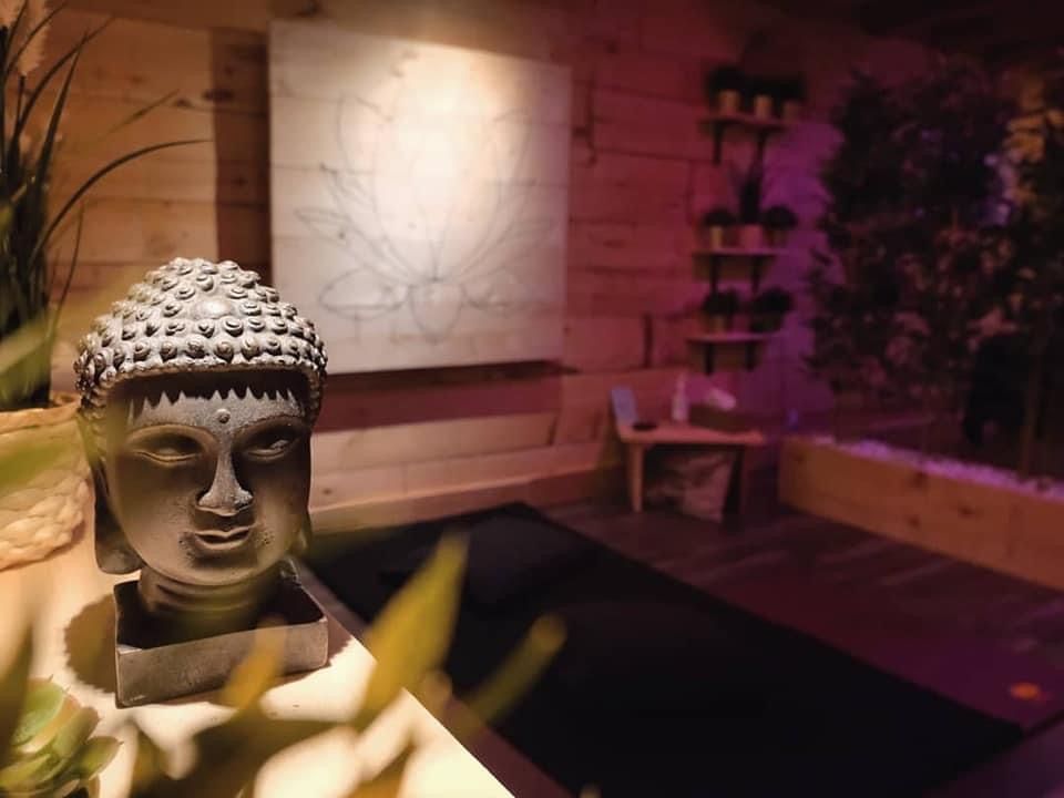 Statue de Bouddha dans un espace de soins du Spa Centrale Parc, où les matériaux naturels et l'éclairage tamisé invitent à la détente.