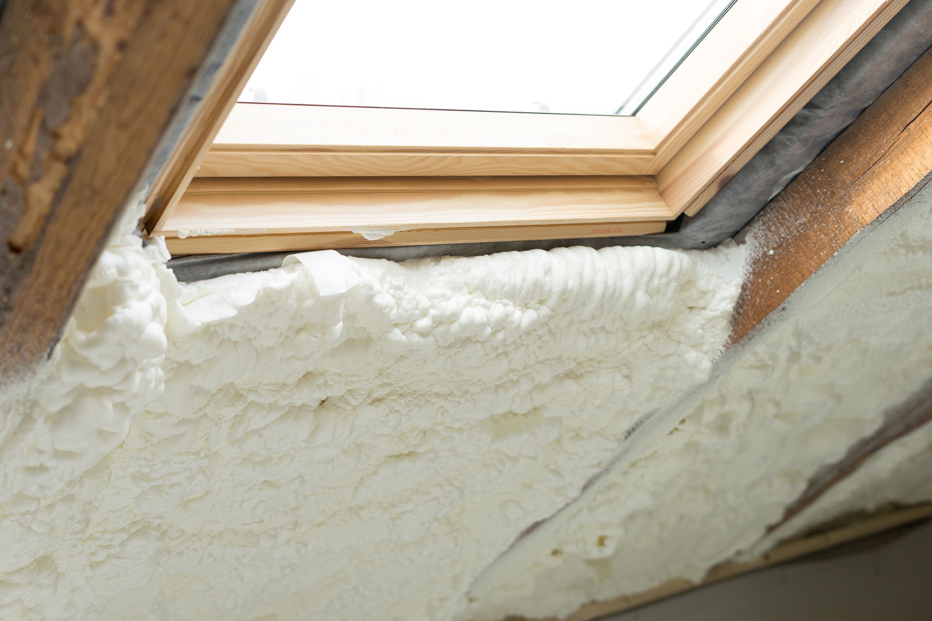 A close up of a skylight with foam insulation around it.