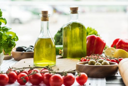 Barattoli di peperoni rossi e pomodori gialli conservati con etichette bianche su un tavolo