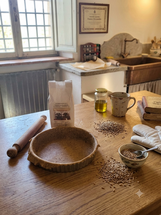Bottiglia su un tavolo di legno accanto a un mattarello, con uno sfondo sfocato di una cucina.