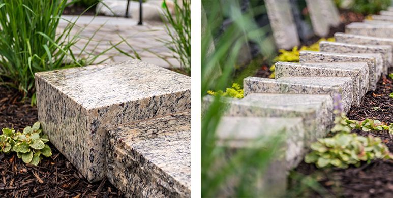 Stone garden edging blocks beside a walkway, with moss and plants in the background