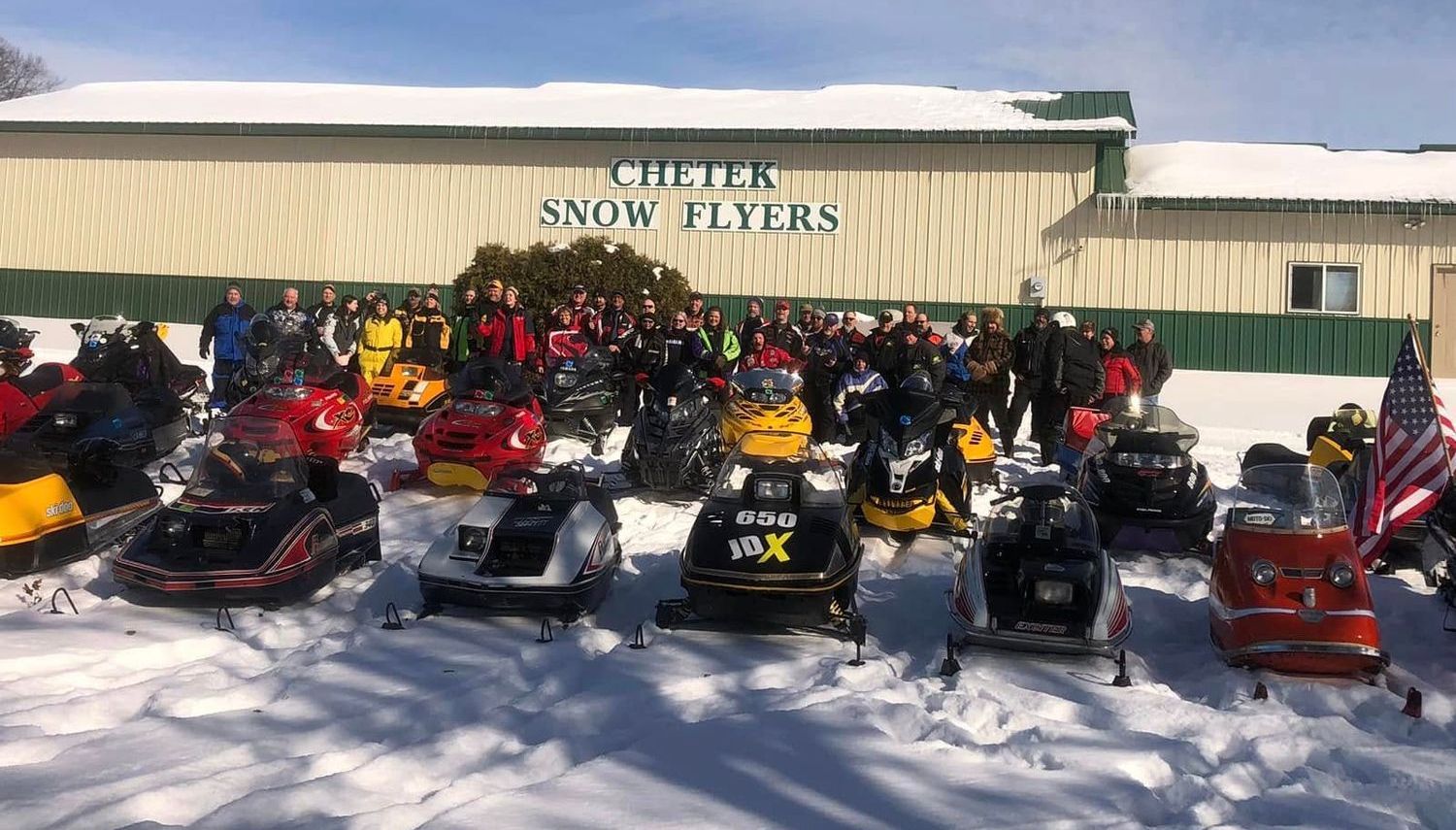 Snowmobiles parked in front of a building with the words 