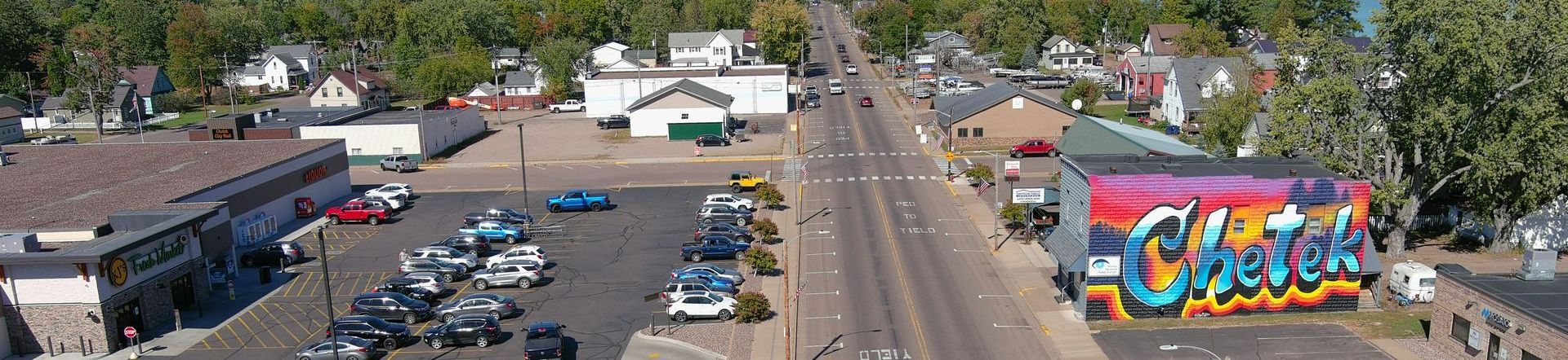 Aerial view of a town with a street, buildings, cars, and graffiti.
