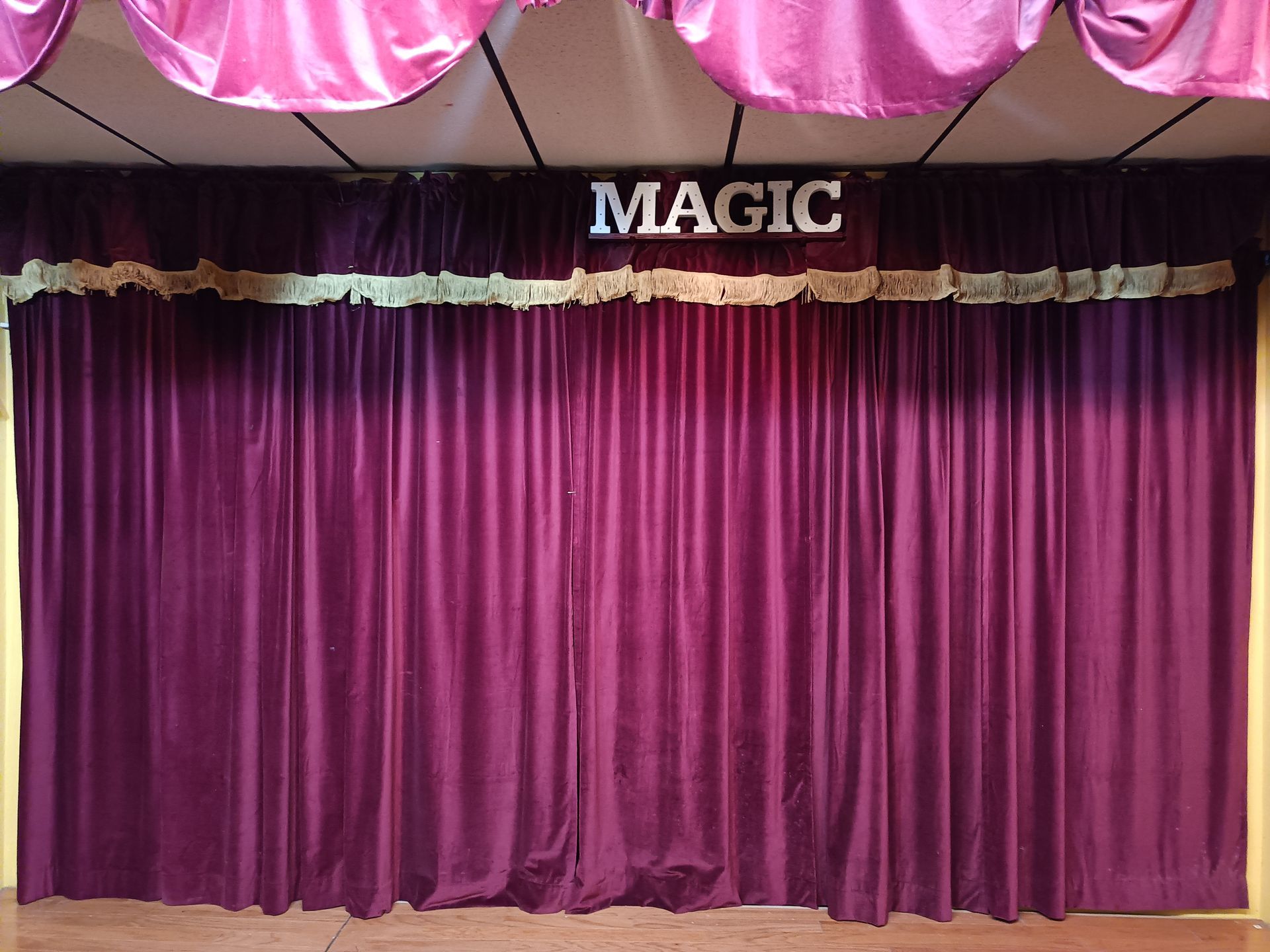 A stage with purple curtains and a sign that says magic.