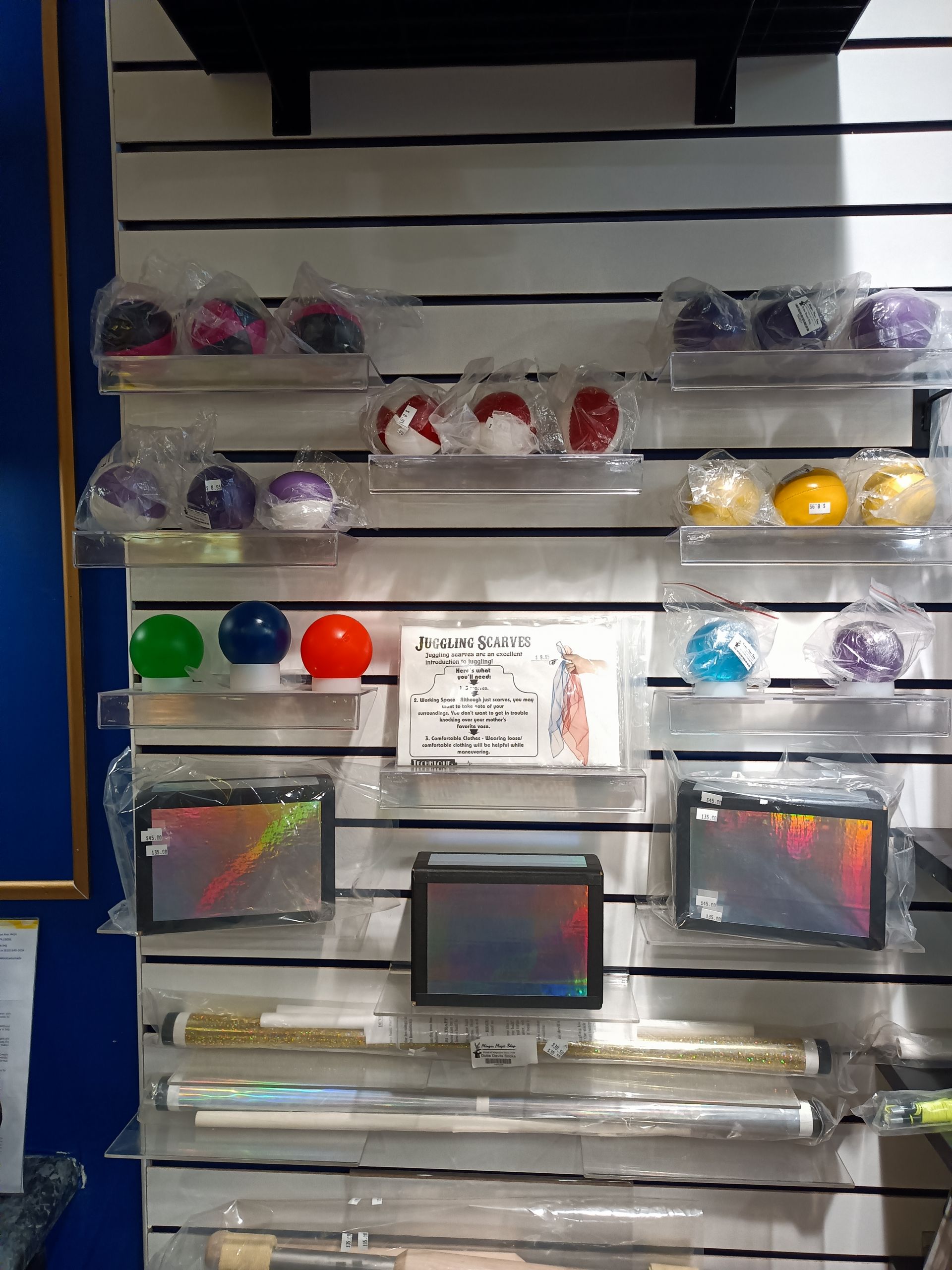 A wall filled with a variety of balls , sticks , and other items.