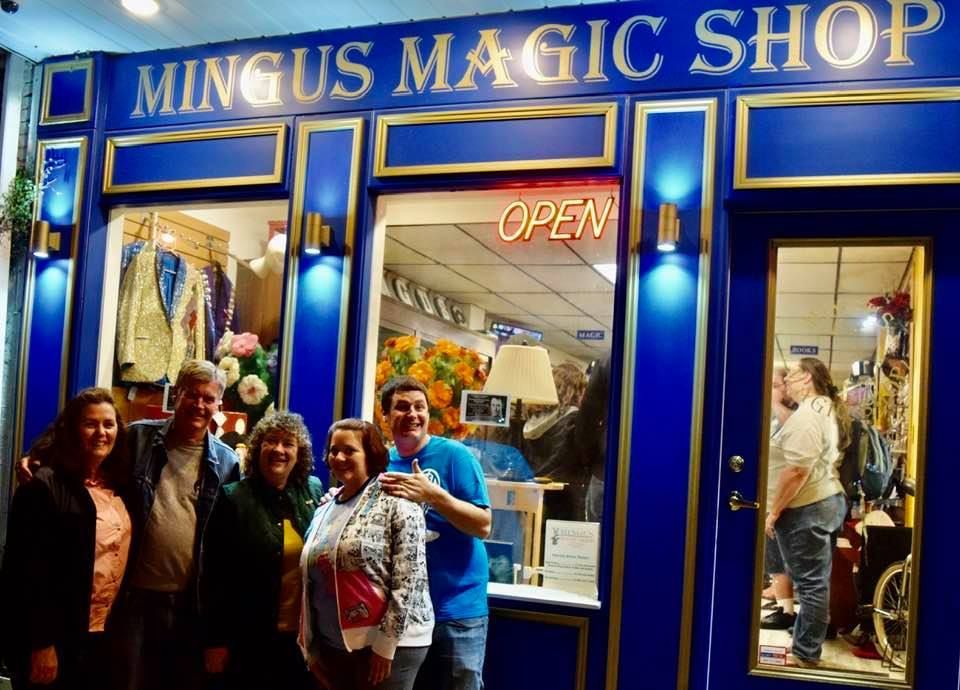 A group of people standing in front of a magic shop