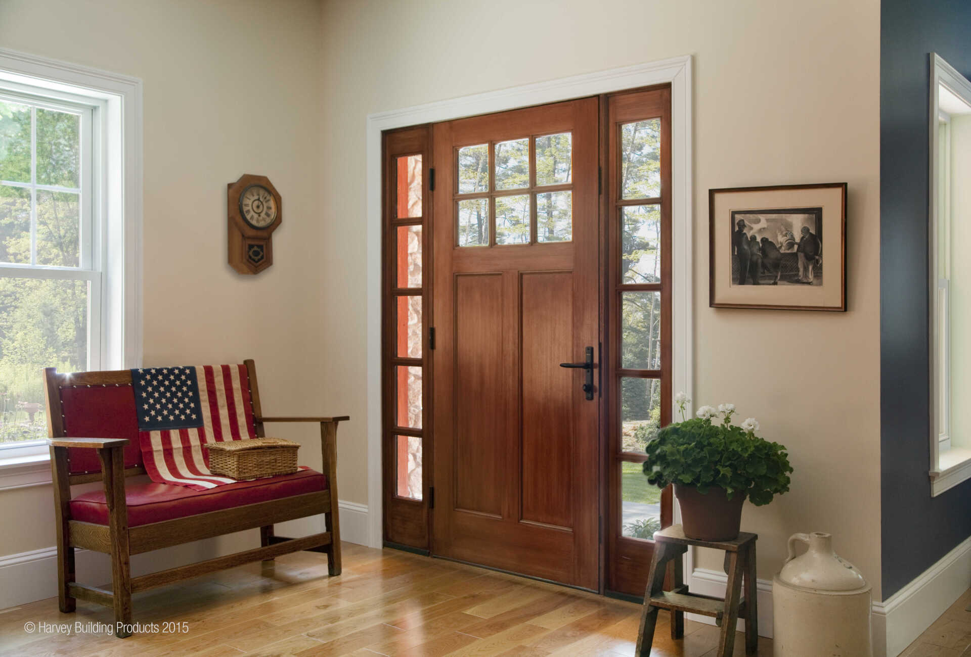 Front entryway with wooden door, patriotic bench, wall clock, framed art, and potted plant