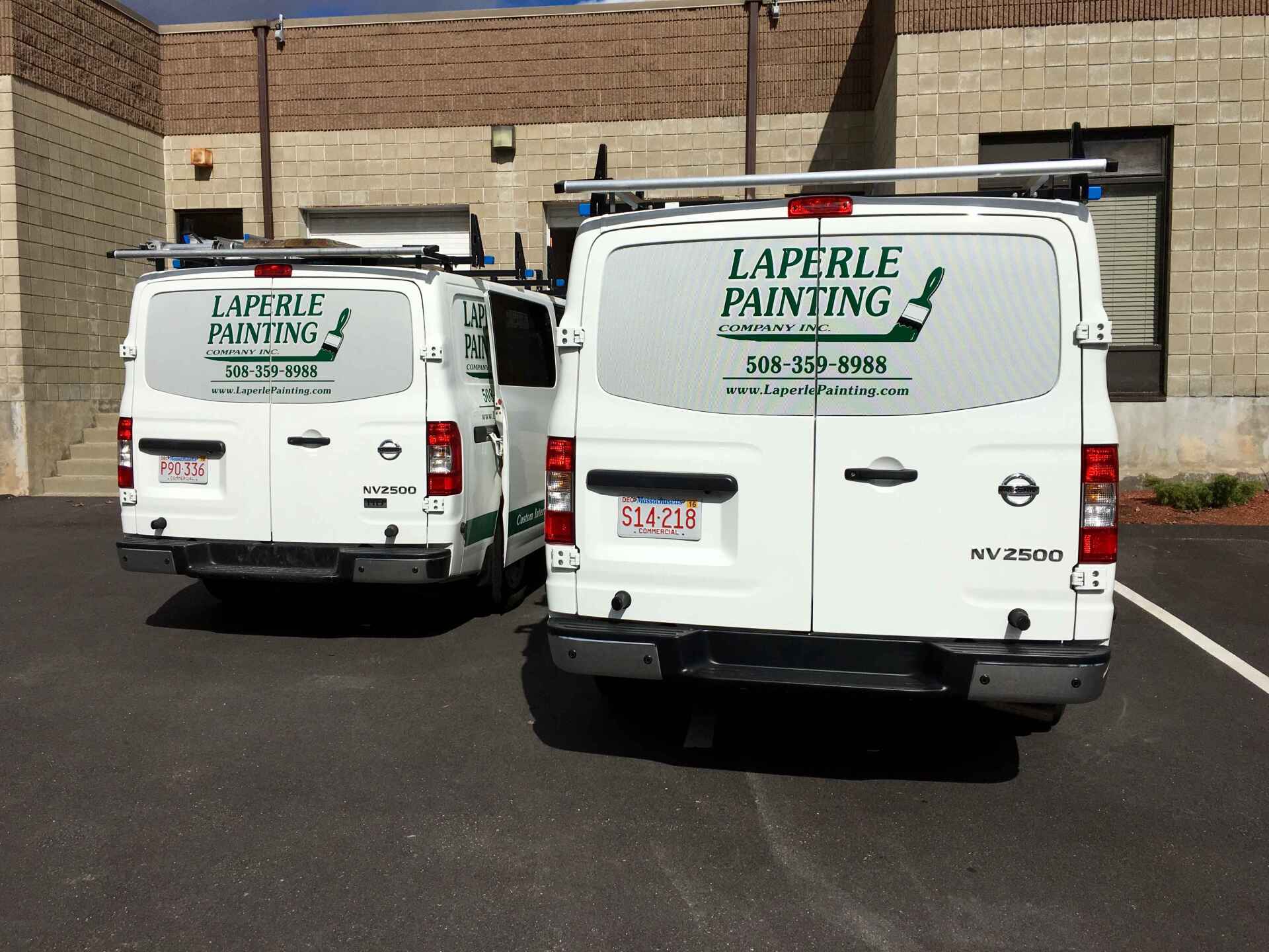 Two white LaPelle Painting vans parked in front of a brick building.