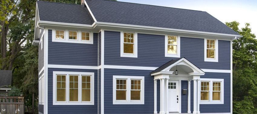 Blue two-story house with white trim, front porch, and multiple windows