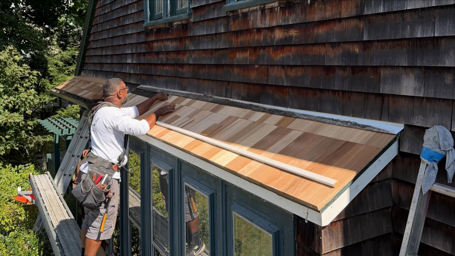 Laperle Painting carpenters re-roofing a projecting window overhang on a historic 1910 home in Medfield, MA
