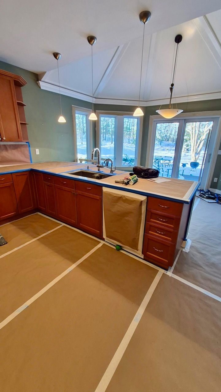 Before photo of Medfield MA kitchen with raised-panel wood cabinets in honey stain and stainless steel appliances before Laperle Painting transformation